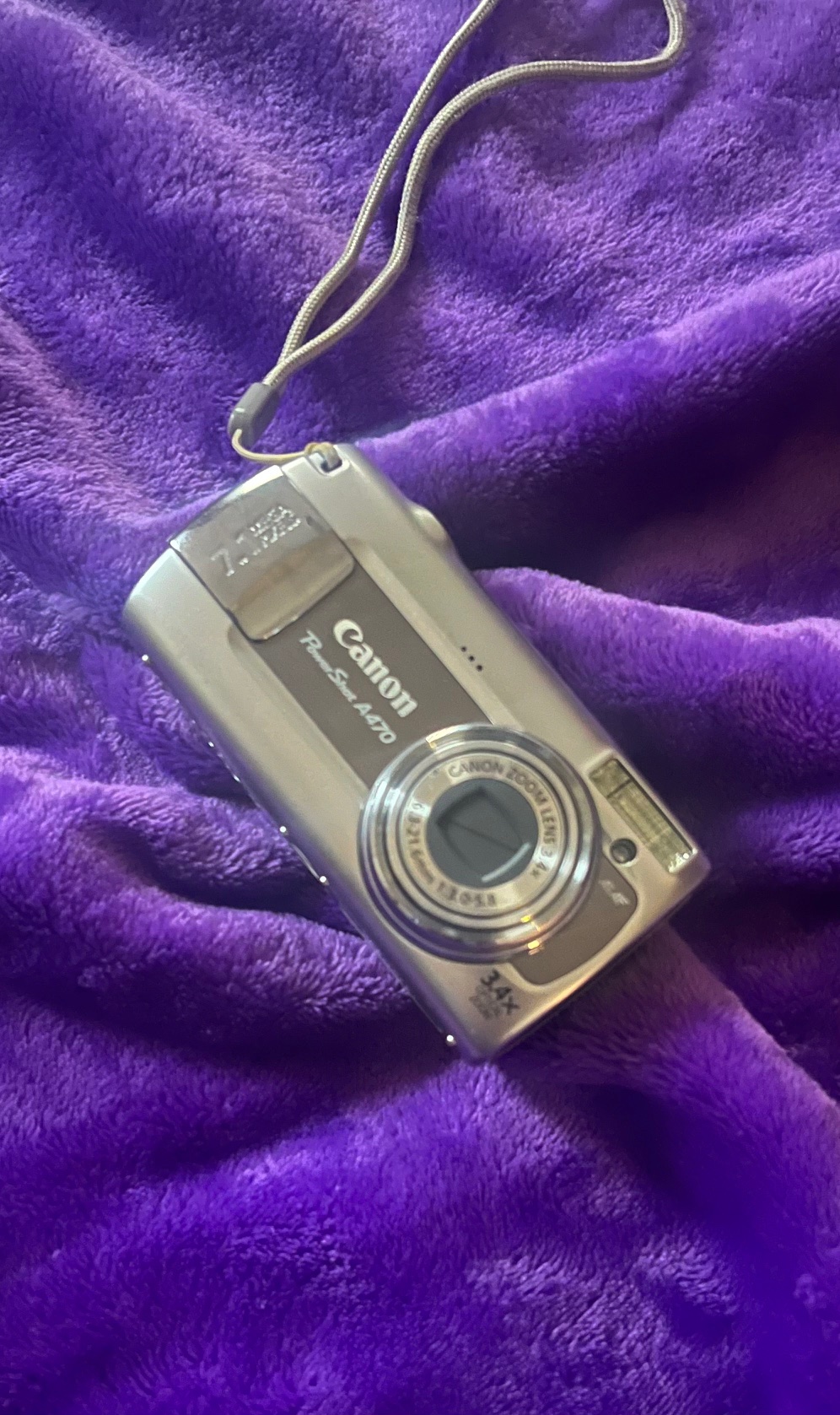 Photo of a Canon A470 Camera on a purple, velvet background.